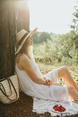 Young woman enjoying nature with cherries and sunlight