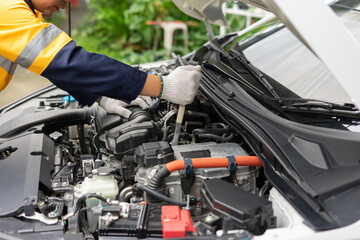 Mechanic inspects car engine with focus and precision