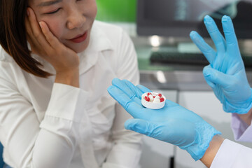 Dentist explains dental treatment options to patient using model