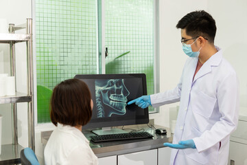 Dentist explains dental X ray to patient in clinic