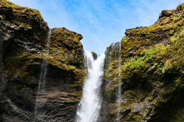 Fototapeta premium Kvernufoss is a hidden waterfall near Skógafoss, reachable through a short, scenic hike. You can even walk behind it for a magical view.