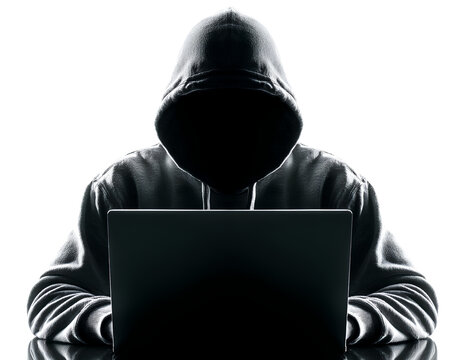 A hacker wearing a hoodie sits at a laptop, isolated against a white background