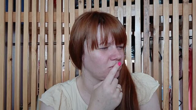 Redhead woman is thinking or remembering something, the woman is in the dressing room
