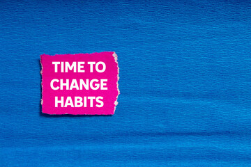 Time to change habits message written on ripped torn pink paper on blue background. Conceptual time...