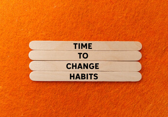 Time to change habits message written on wooden sticks on orange background. Conceptual time to...