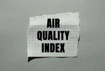 Air Quality Index message written on ripped torn checkered paper piece on grey background....