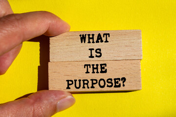 What is the purpose message written on wooden blocks on yellow background. Conceptual what is the...