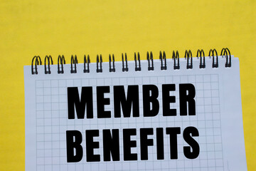 Member benefits message written on notebook page on yellow background. Conceptual member benefits...