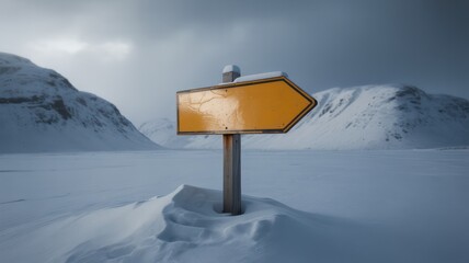 Yellow direction sign in a snowy landscape with mountains under a cloudy sky in winter scenery
