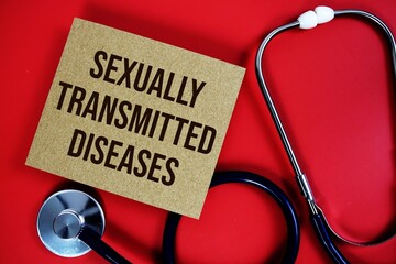 Sexually Transmitted Diseases; text written on paper card with stethoscope on red background