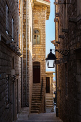 Narrow stone street with lantern and stairway in Ulcinj Old Town at sunset, Montenegro