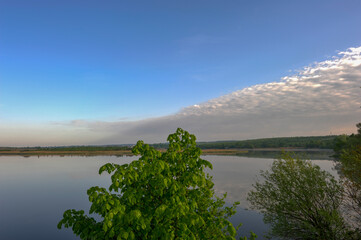 Beautiful panoramic view of the lake during sunrise. HDR style. Mirror reflection in the water. Morning over the lake and lots of sun.