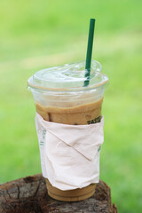 Iced coffee on a dead tree stump
