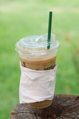 Iced coffee on a dead tree stump