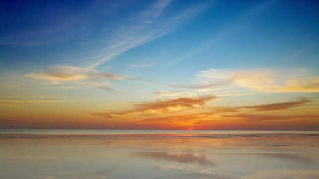 A handheld coastal view captures the soft golden afterglow following sunset&mdash;clouds tinted in warm hues drift gently above a rippling sea, while subtle motion reflects a contemplative human presence in