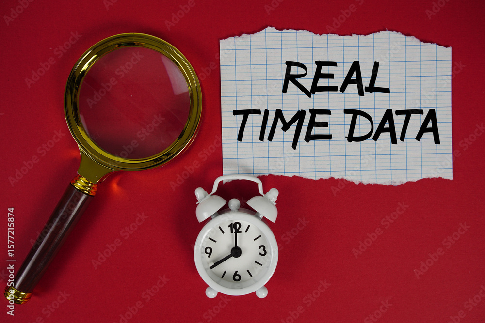 Poster real time data text written on paper with magnifying glass and alarm clock