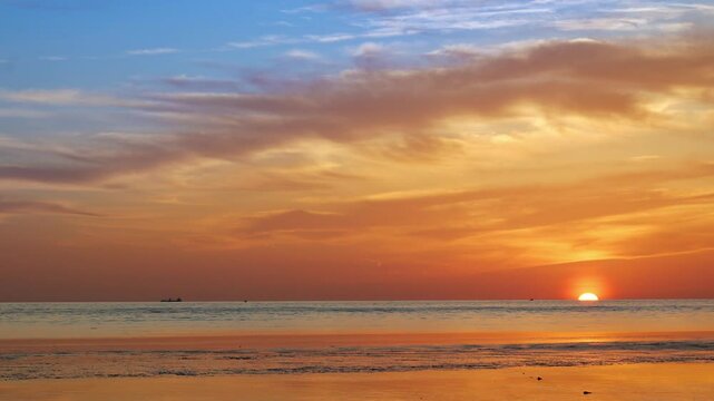 A one-minute real-time sunset shows the sun slowly dipping into the horizon over a gently rippling sea&mdash;golden light stretches across the water, subtle waves shimmer, and distant boats remain still in 