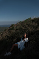 Naklejka premium A beautiful girl in a sarafan walks in the mountains. Wind in her hair.