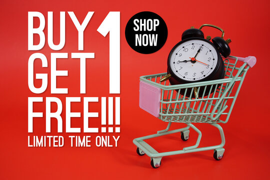 Buy 1 Get 1 Free!! Promotion and Marketing with trolley shopping cart and alarm clock on red background
