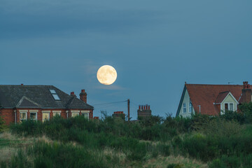 Full moon above buildings in Norwich. England
