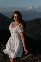 A beautiful girl in a sarafan walks in the mountains. Wind in her hair.