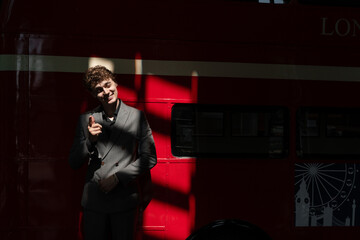Portrait of a man against a red wall with liquid shadows