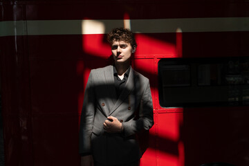 Portrait of a man against a red wall with liquid shadows