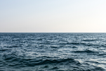 clear empty horizon line above still calm sea surface. natural composition with clarity, balance, and peaceful tones. minimalistic nature art