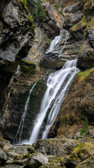 A vertical view of a stunning waterfall in Ordesa and Monte Perdido National Park, Huesca, Aragon, Spain, on a cold autumn day.