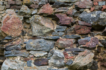 Fragment of old defense stone wall of ruined medieval castle