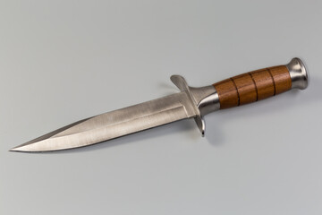 Non-folding hunting knife with wooden handle on gray background