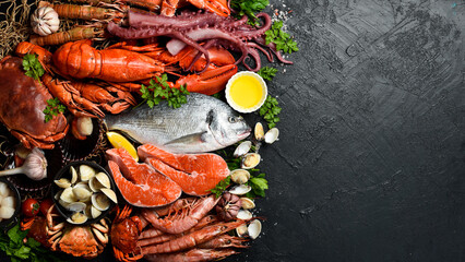 Many different fresh seafood: Fish, clams, crustaceans, lobster and octopus on slate black table. Free space for text or design. © Yaruniv-Studio