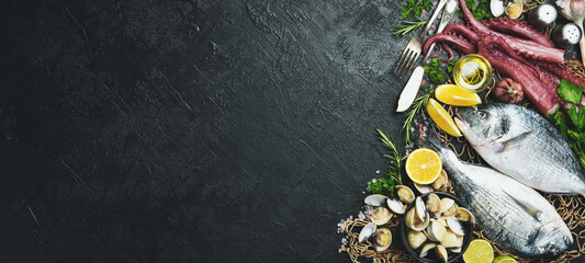 Fresh dorado fish and seafood on slate stone background. Seafood banner. Top view.