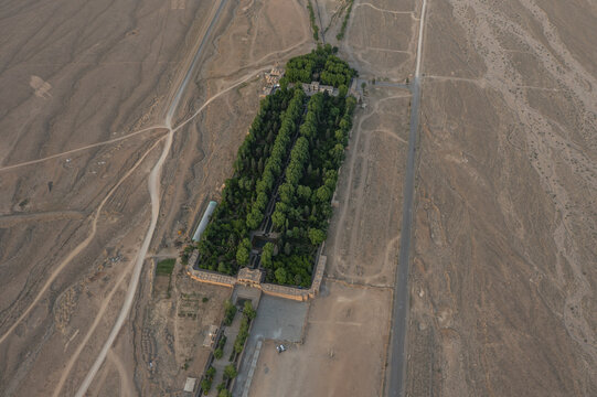 Aerial view of a lush garden contrasting with the surrounding arid landscape, framed by pathways and earth tones, creating a serene oasis., Kerman, Kerman Province, Iran.