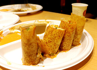 A plate full of delicious Indian pizza Dosa wraps with sambhar a