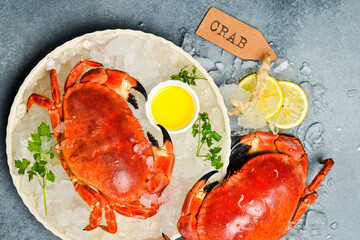 Delicious boiled crab with butter and spices on ice in a plate.