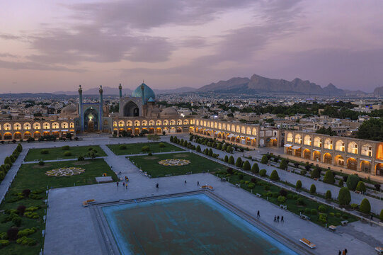 Aerial view of the mesmerizing Imam Mosque with its turquoise dome, and the vast, ornate Naqsh-e Jahan Square contrasting with the dusky sky, Isfahan, Isfahan Province, Iran.