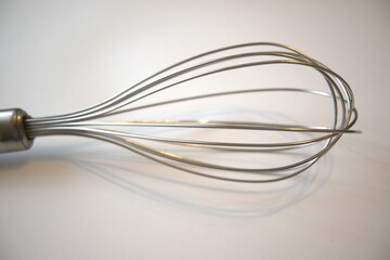 One whisk close up with white background.