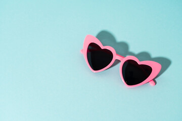 Heart-shaped glasses on a colored background.
