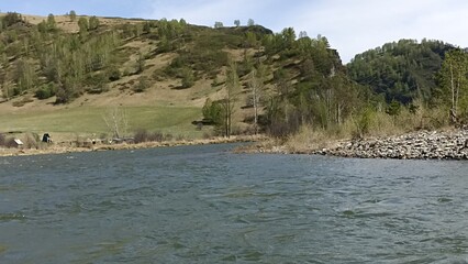 Picturesque mountain river landscape with lush vegetation and clear blue sky above scenery