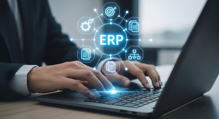 Modern businessman using a laptop displaying a glowing ERP system management interface for efficient business process organization and data analysis