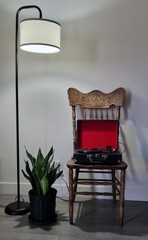 A stylish retro-inspired home interior featuring a carved wooden chair with a red record player, a...