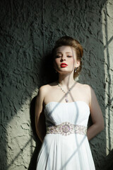 Fototapeta premium An Elegant Woman Dressed in a Beautiful White Dress with Bold and Striking Red Lips