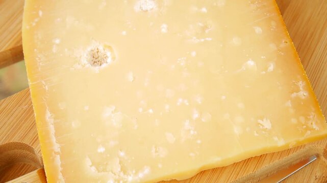 Maasdam cheese slices arranged on a wooden cutting board, creating a visually appealing presentation.