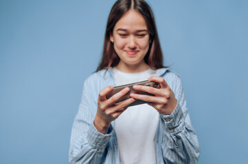 young woman delightedly engages with her smartphone, showcasing the joy of connectivity on light...
