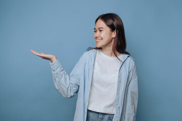 young woman confidently displays her hand, suggesting an invitation to explore what's unseen on...