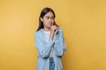 A young woman appears deep in thought, her demeanor reflecting reflection and consideration against...