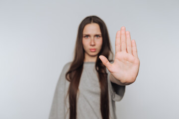 woman confidently raises her hand in a stopping gesture, symbolizing the importance of boundaries...