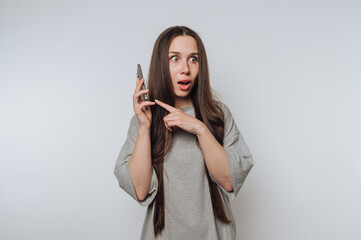surprised woman gestures while speaking on her smartphone on white background