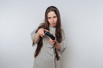 playful young woman teases the camera while holding a gaming controller, displaying a sense of fun...